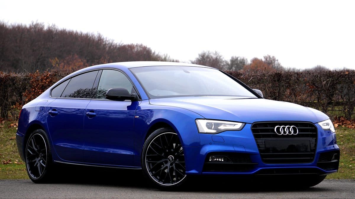 Blue Audi A5 Sportback parked on a country road against the original background